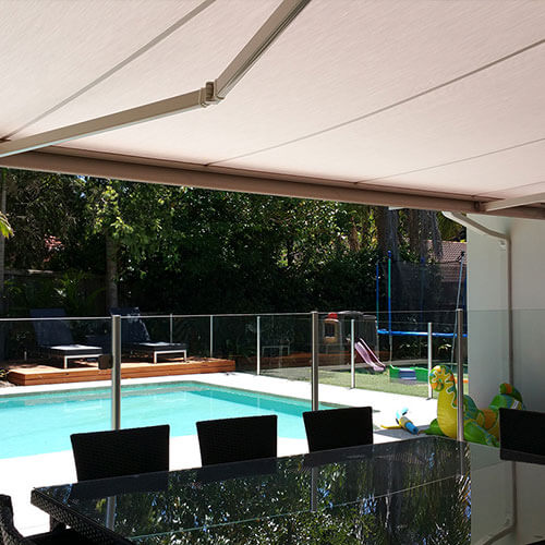 A retractable awning from The Blind Shop in Canberra overlooking a backyard pool