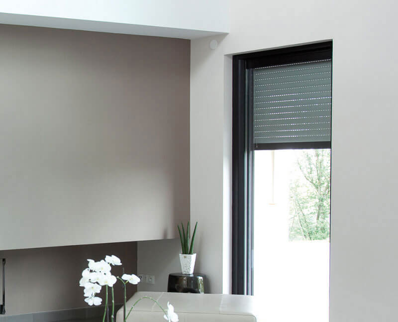 A portrait image of roller shutters being used in a modern, Canberra loungeroom. Get yours from The Blind Shop today!