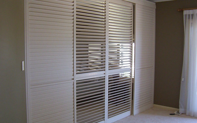 White vogue shutters in a bedroom. Order yours from The Blind Shop in Canberra!